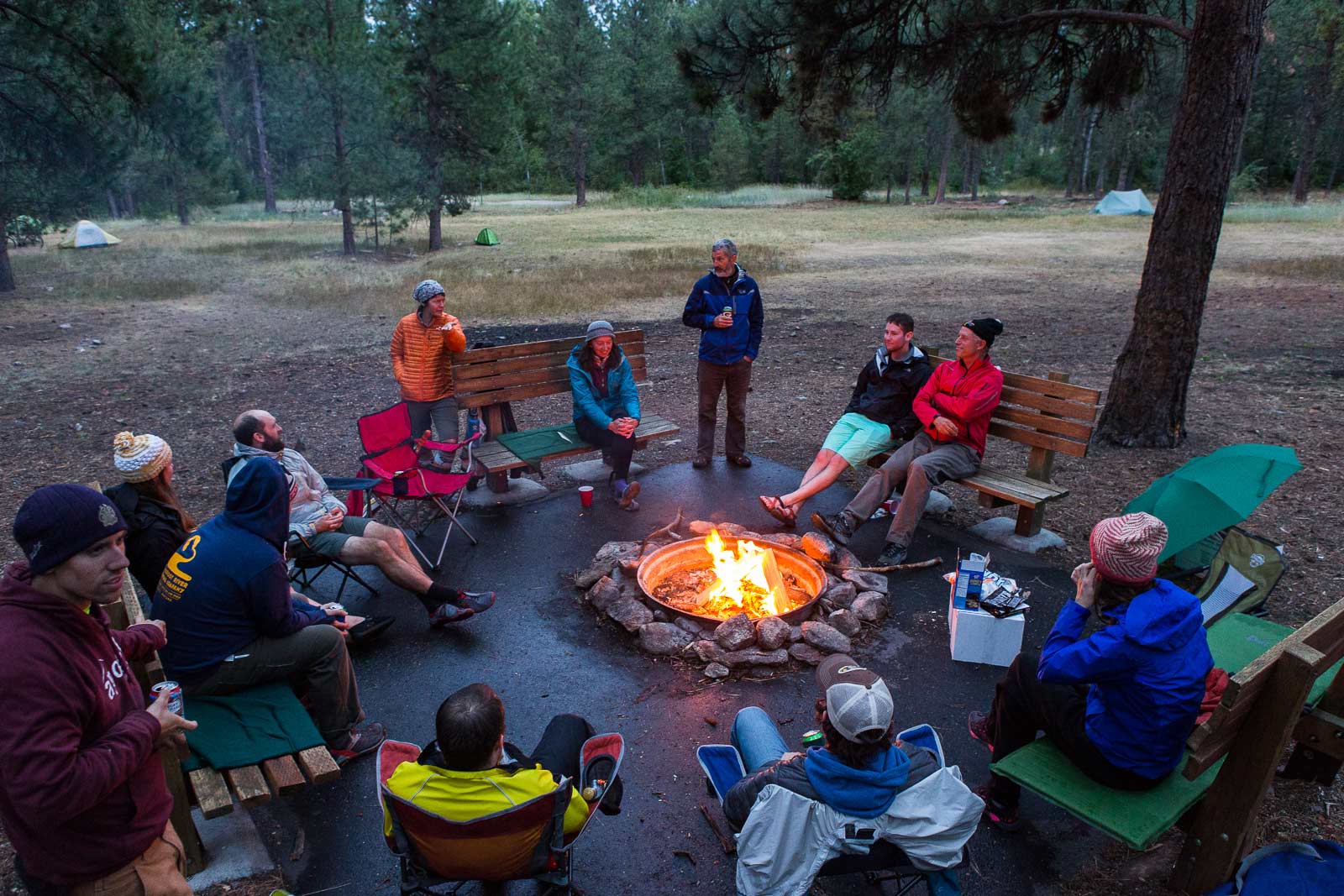 A group of friends gather around the fire after a day on the Bitterroot Trail